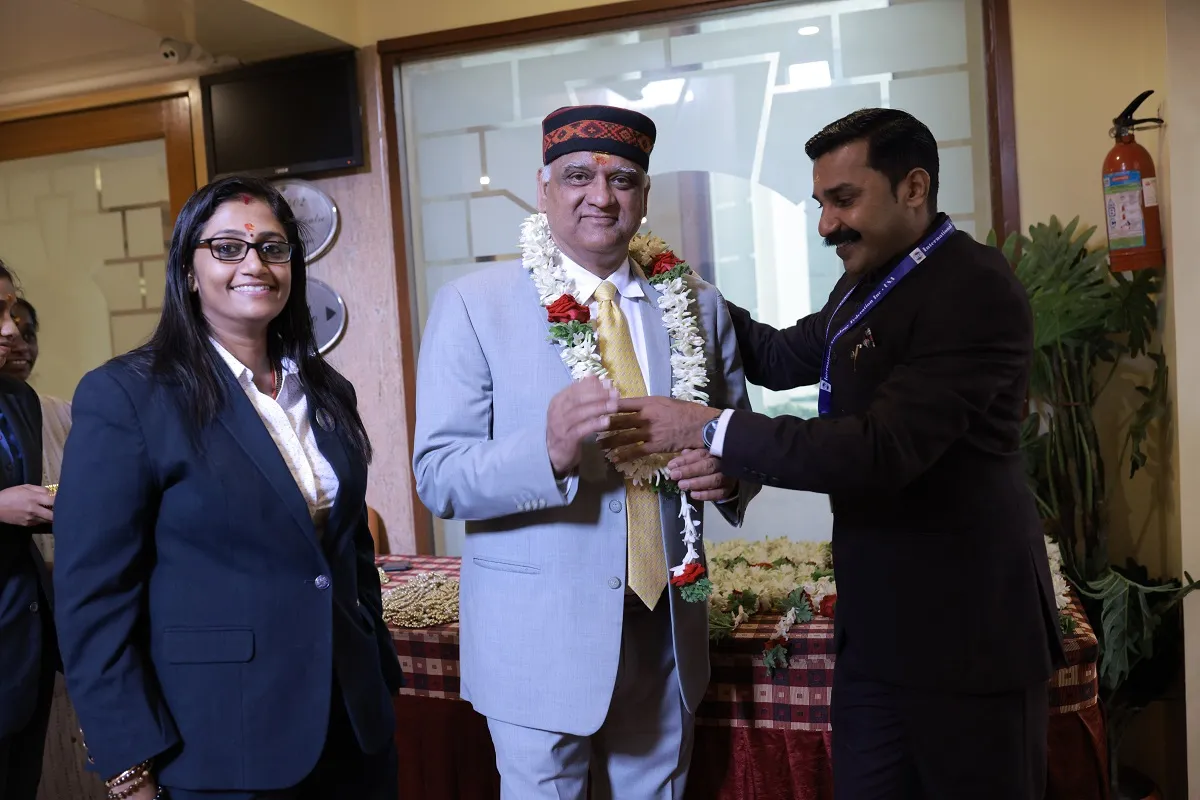 Acharya Hari Sharma being garlanded at a felicitation ceremony